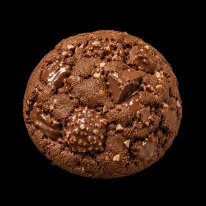 A single rocher cookie with milk chocolate chunks and cookie crumbs, isolated on a solid black background.